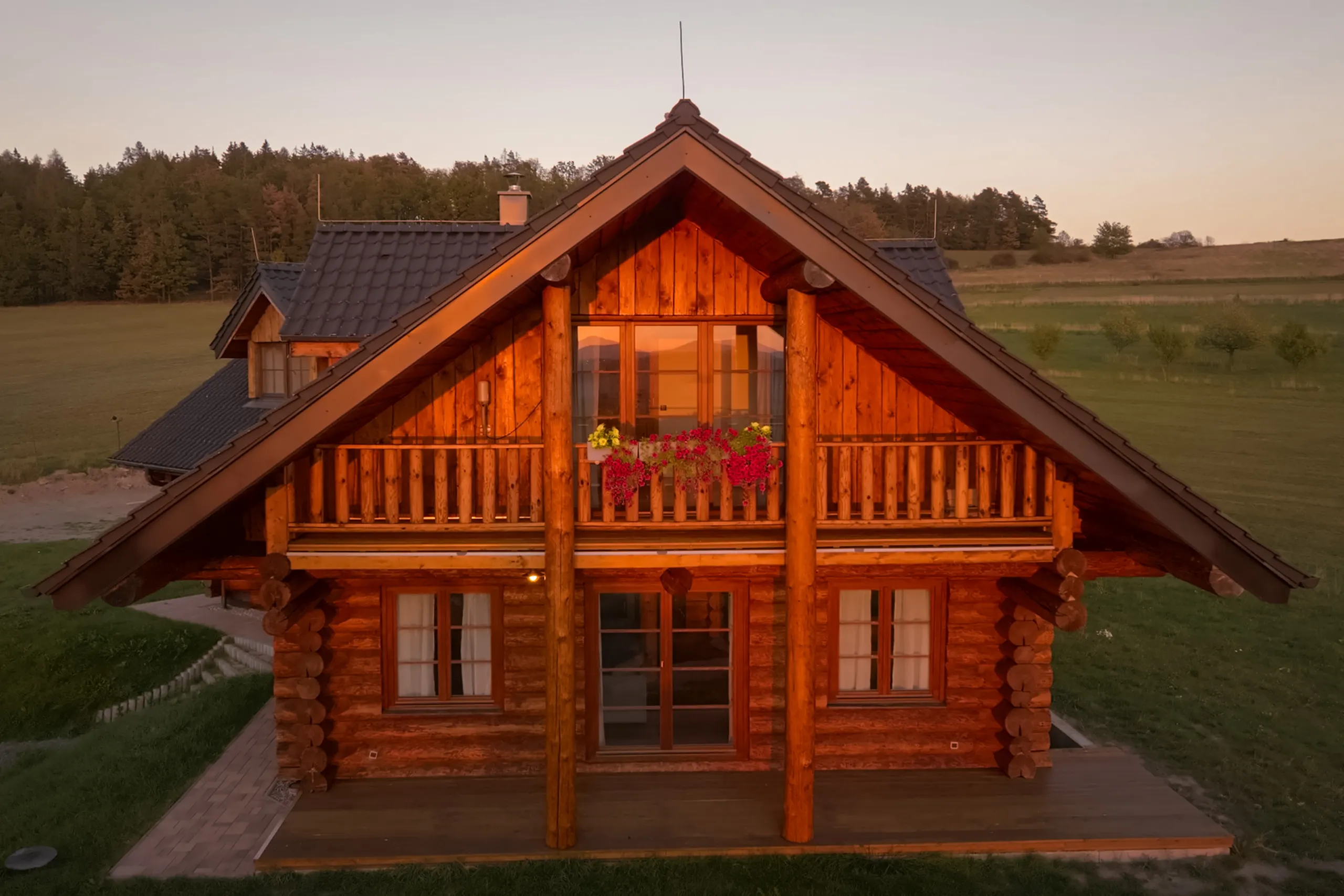 Štít srubu s balkonem a květinami