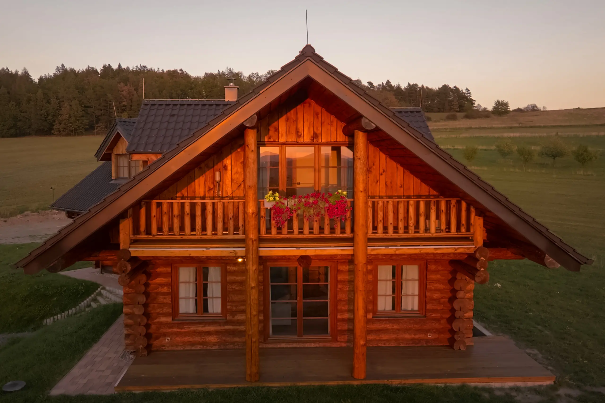 Štít srubu s balkonem a květinami